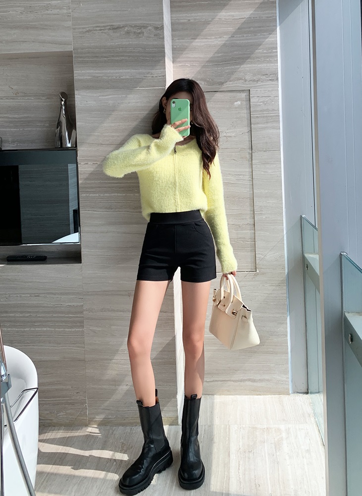 เสื้อกันหนาวไหมพรมสีเขียวอ่อนคู่กับกางเกงขาสั้นสีดำกำมะหยี่ผ้าและรองเท้าบูทหนังสีดำครึ่งเข่า